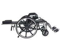 Load image into Gallery viewer, A black and silver medical-style wheelchair with an attached side table and padded armrests, shown from the side against a plain white background.